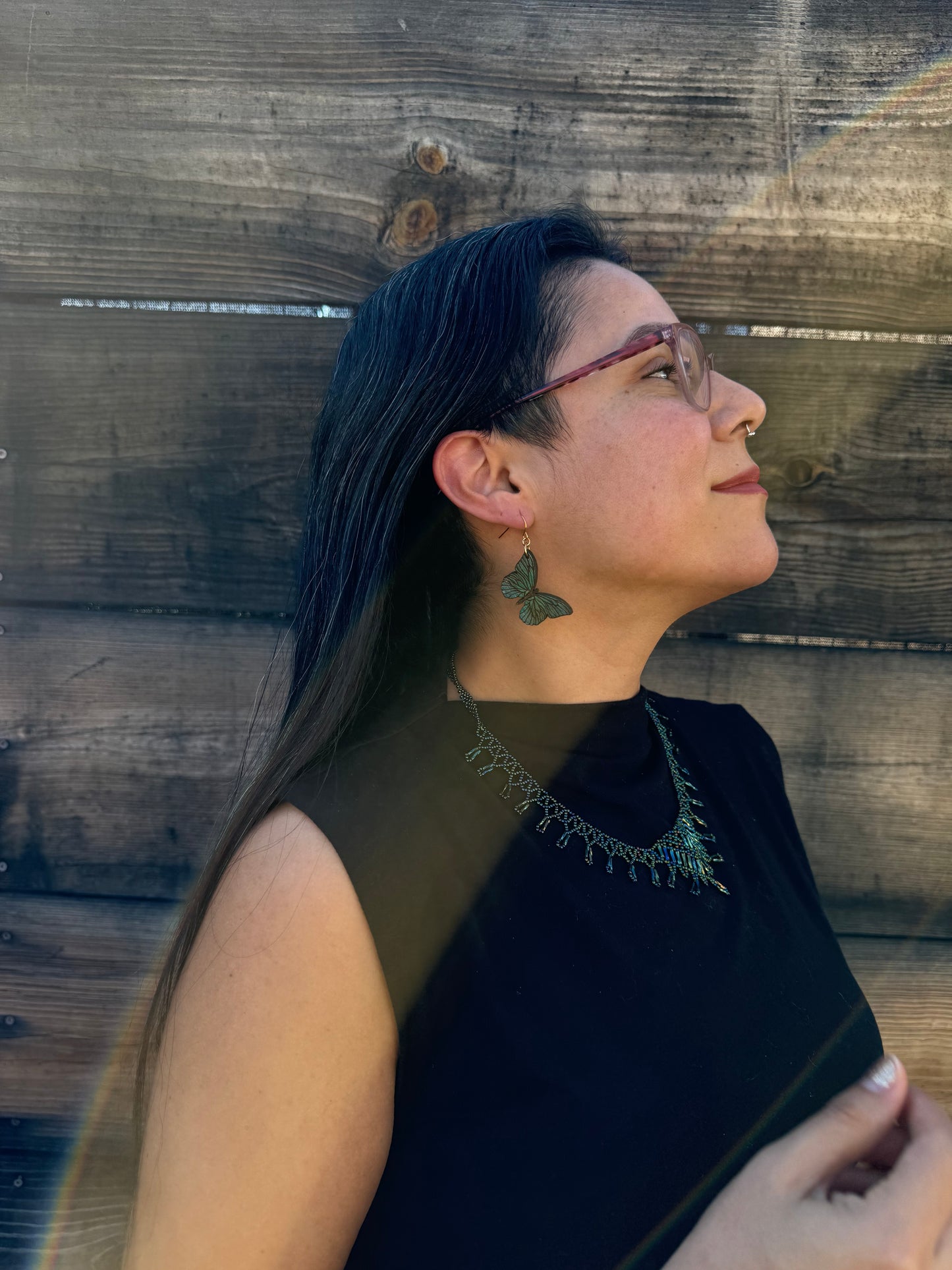 Person wearing blue butterfly earrings.