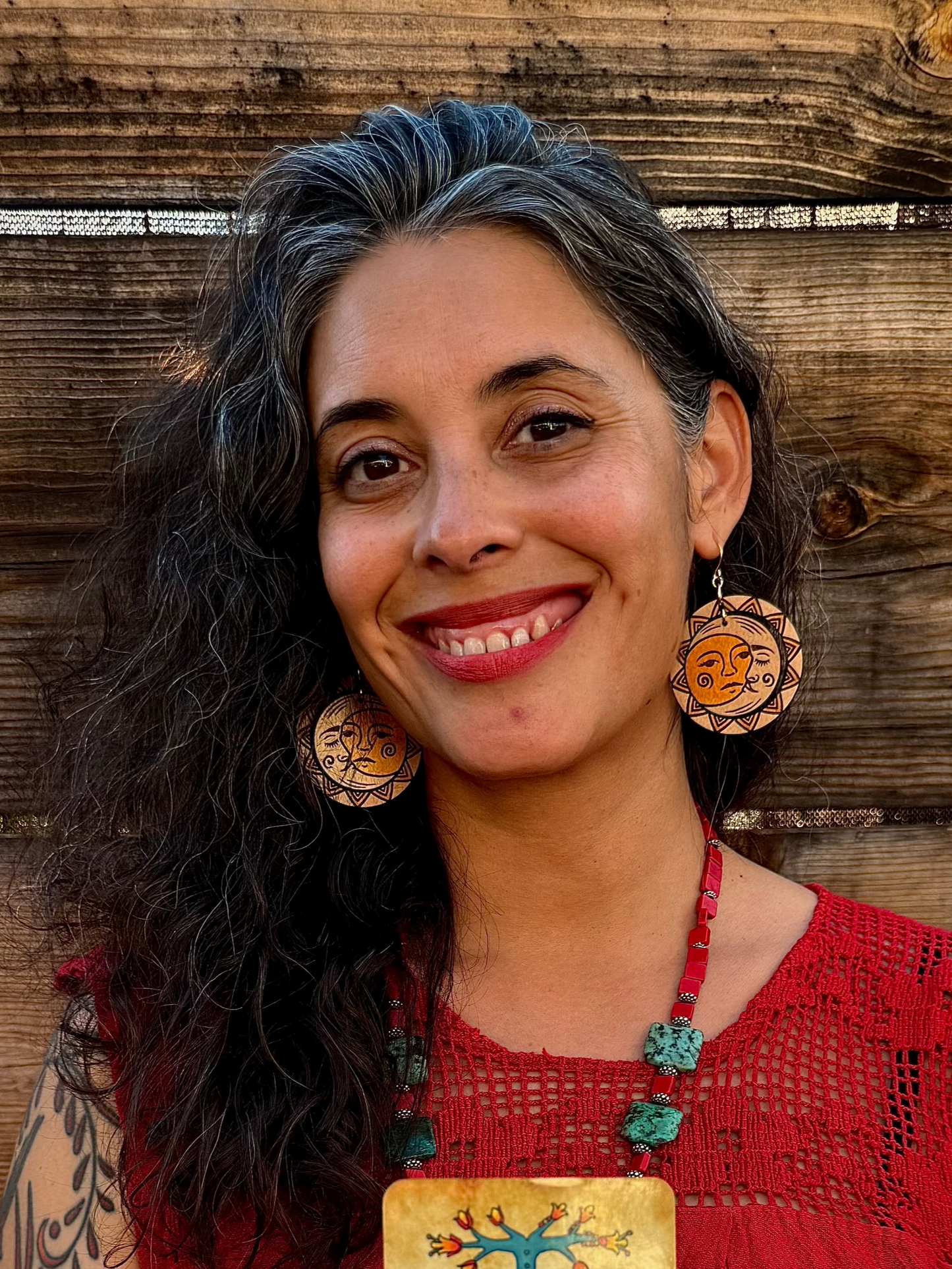 woman wearing solar eclipse wood engraved earrings.
