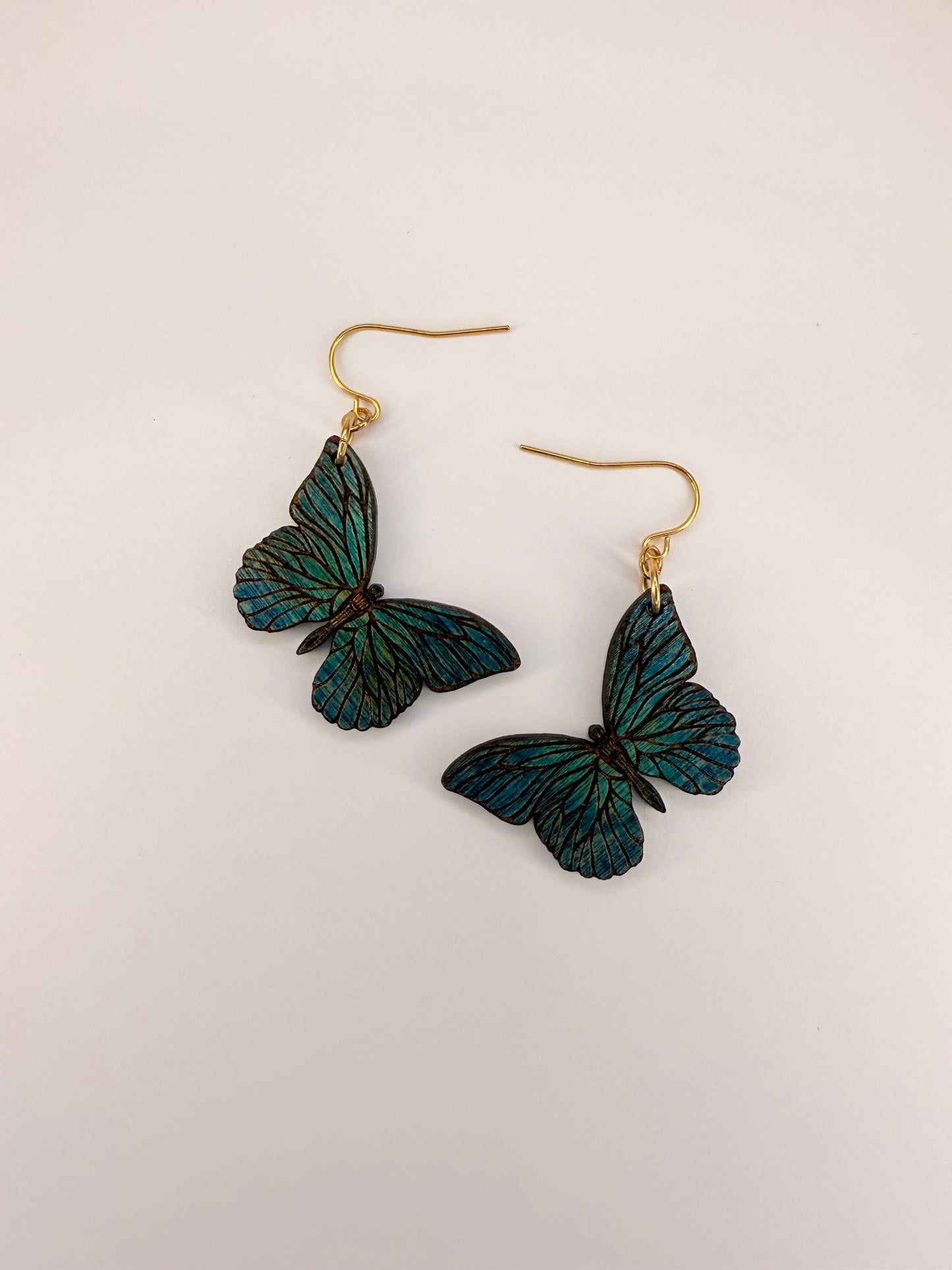 Blue butterfly-shaped earrings on a light background.