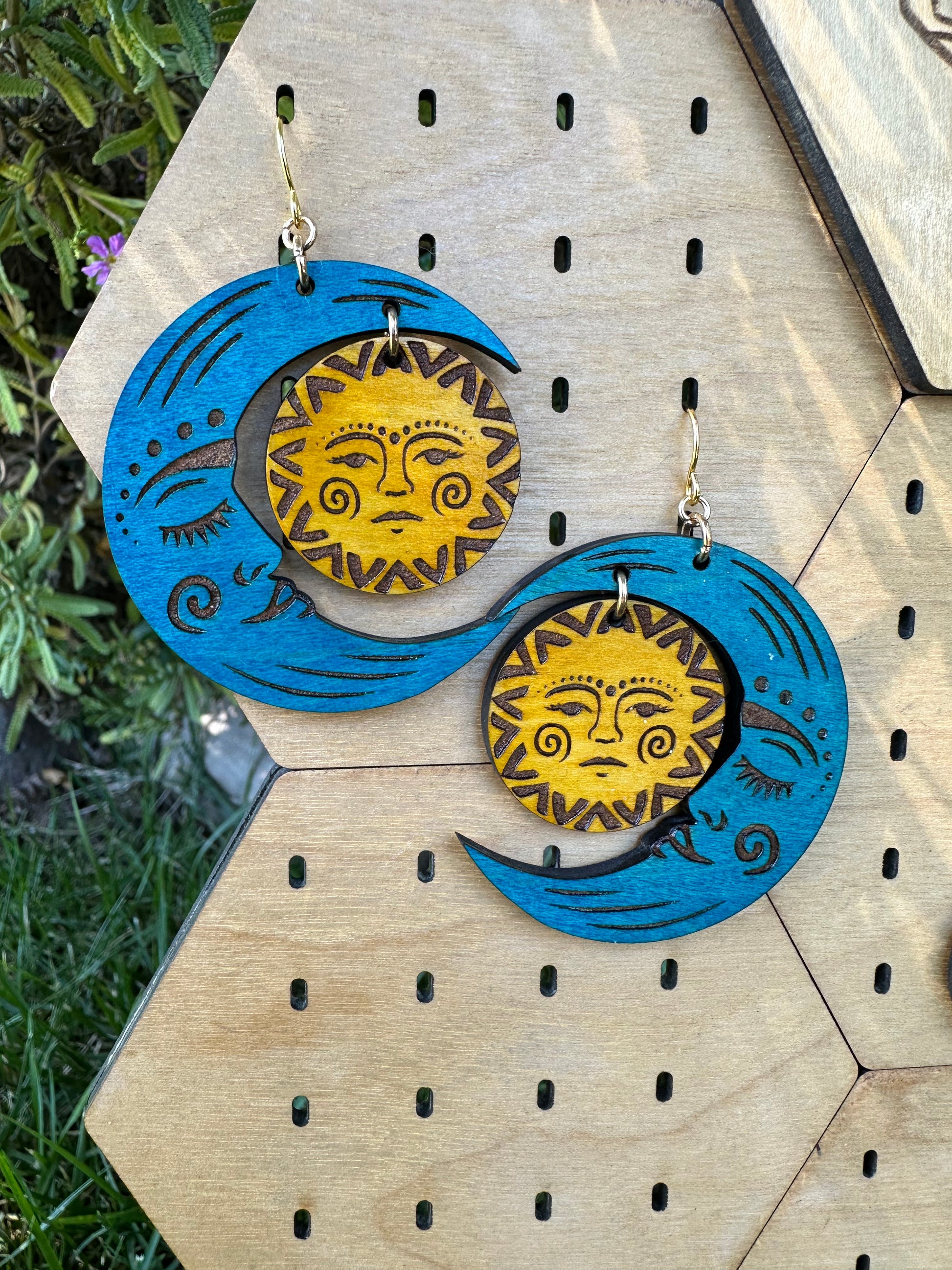 wood engraved blue crescent moon with face with yellow sun with face earrings with gold colored hypoallergenic earring hooks. 