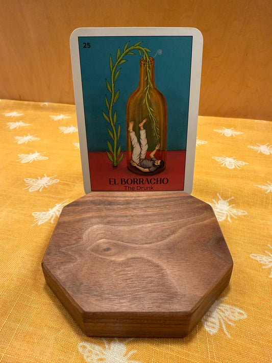 dark walnut tarot card holder with an oracle card on a patterned fabric. 