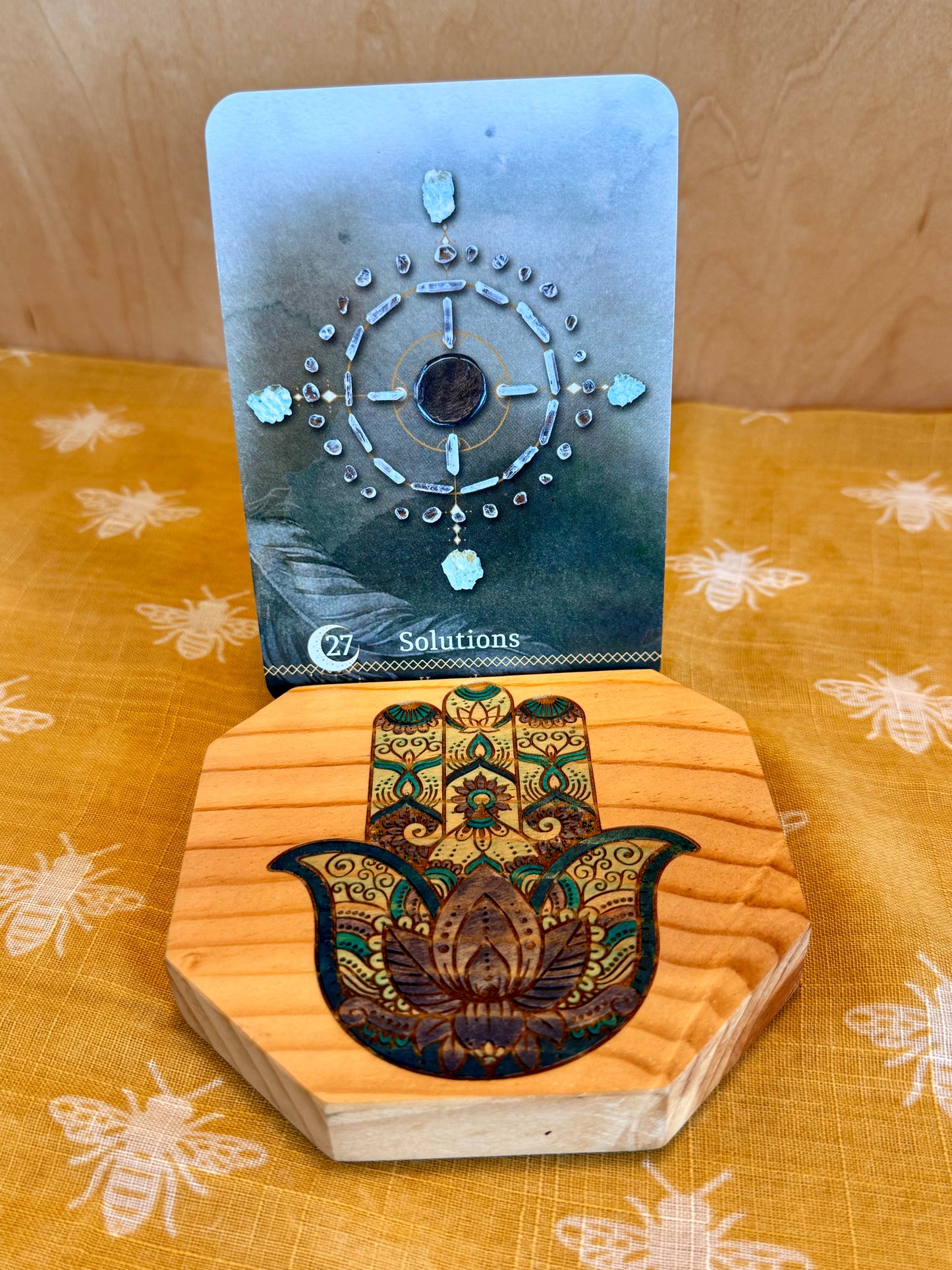 hamsa hand card holder with oracle card picturing a crystal grid. 